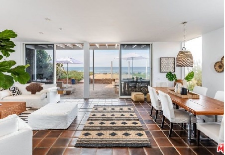 inside view of Denise Richard house in Malibu with a white sofa and table with ocean view